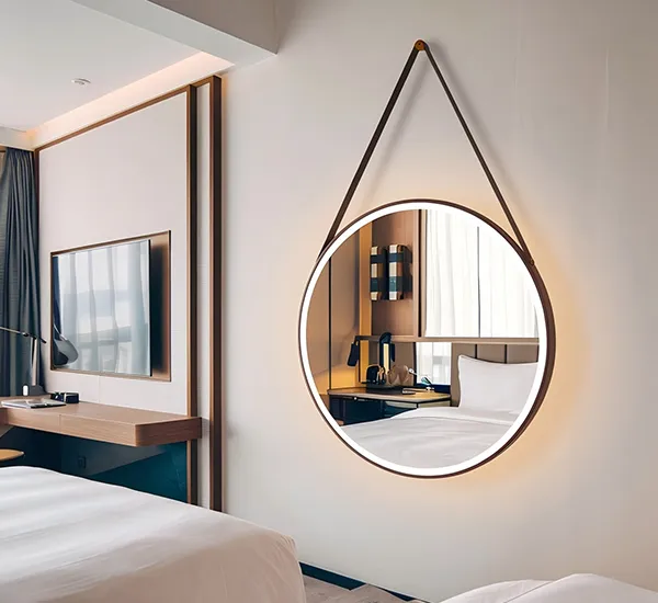 Accrocher des miroirs ronds à diodes électroluminescentes dans une chambre d'hôtel